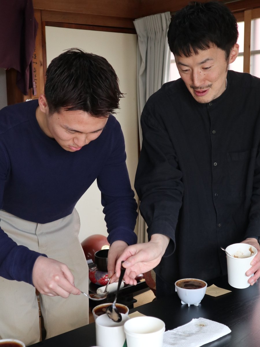 カッピングの手元で味の見方を伝える様子